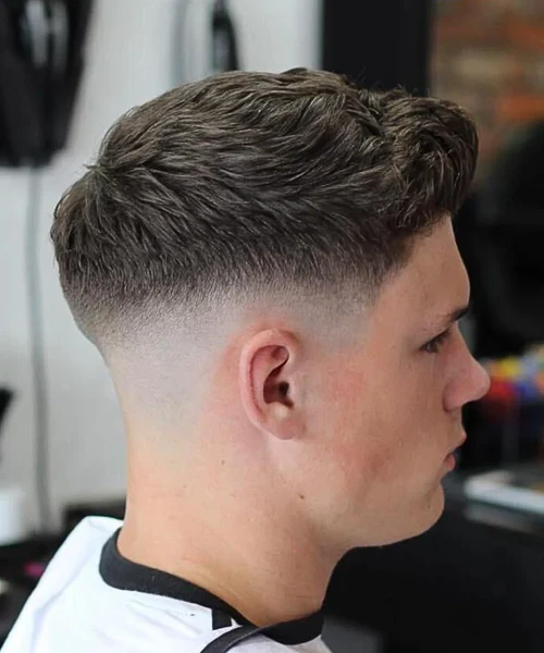Mid fade haircut with natural textured top for men
